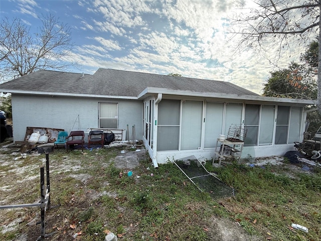 rear view of house featuring a sunroom