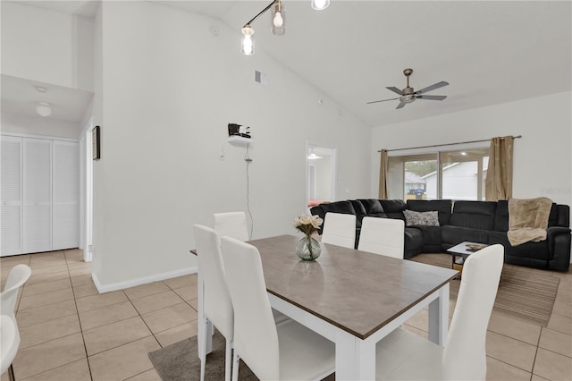 tiled dining area with high vaulted ceiling and ceiling fan