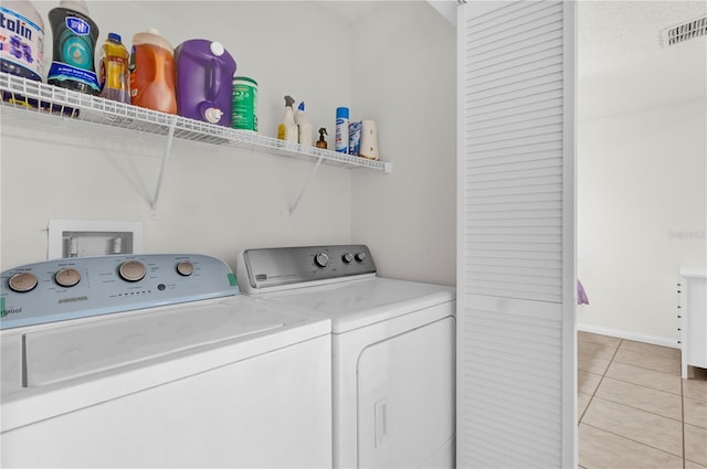 washroom featuring light tile patterned floors and washer and clothes dryer