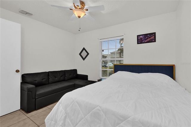 bedroom with ceiling fan, a textured ceiling, and light tile patterned floors