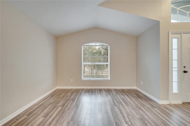 foyer entrance with lofted ceiling and light hardwood / wood-style floors