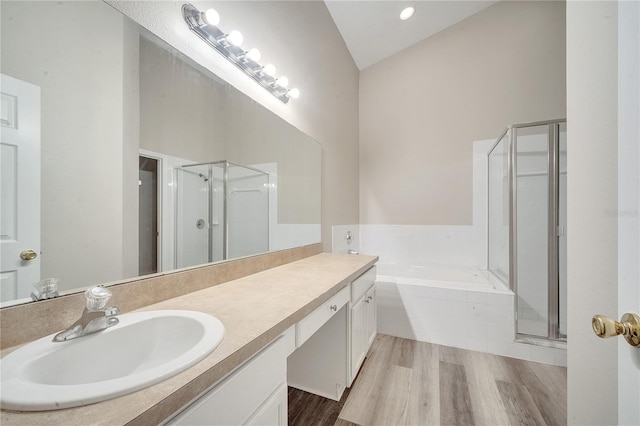 bathroom featuring lofted ceiling, wood-type flooring, vanity, and shower with separate bathtub