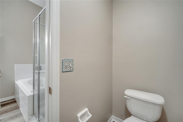 bathroom with toilet, hardwood / wood-style floors, and plus walk in shower