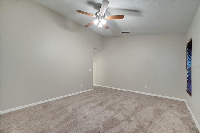 empty room with a textured ceiling, ceiling fan, and light colored carpet