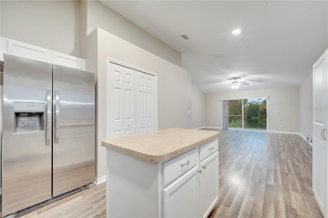 kitchen featuring a kitchen island, stainless steel fridge, light hardwood / wood-style flooring, and white cabinetry