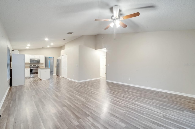 unfurnished living room with lofted ceiling, light wood-type flooring, ceiling fan, and a textured ceiling