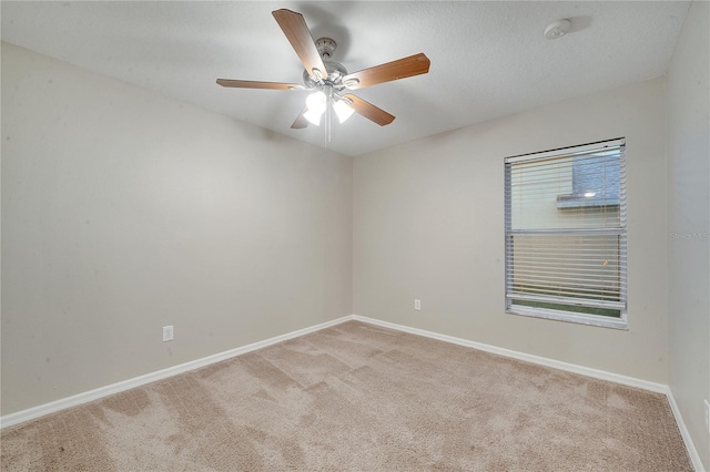 spare room with ceiling fan, light colored carpet, and a textured ceiling