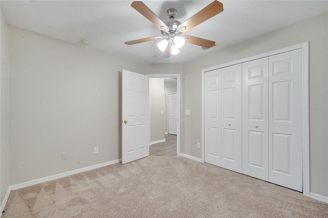 unfurnished bedroom with ceiling fan, light colored carpet, and a closet