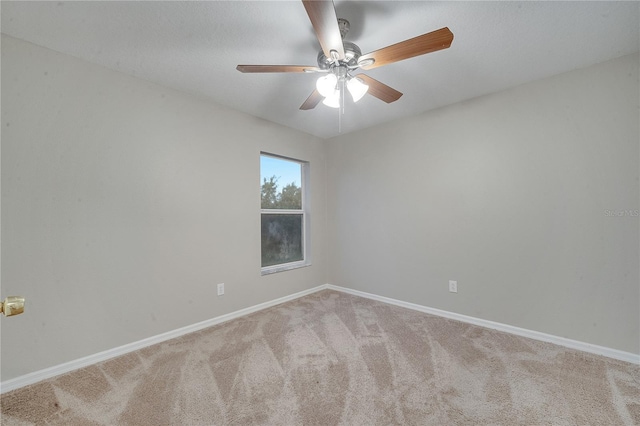 empty room featuring ceiling fan and light colored carpet