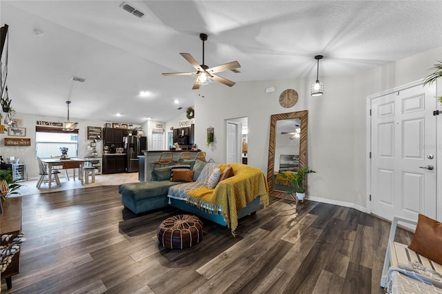 living room featuring a textured ceiling, lofted ceiling, and dark hardwood / wood-style floors