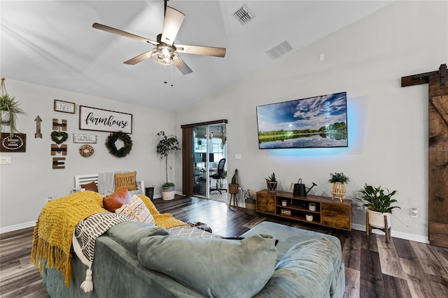 living room with ceiling fan, dark hardwood / wood-style flooring, a barn door, and vaulted ceiling