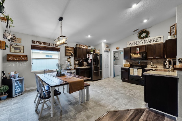 kitchen featuring sink, dark brown cabinets, pendant lighting, and black appliances