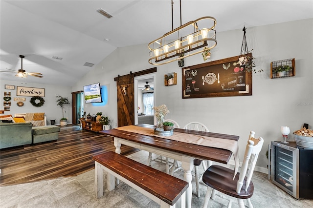 dining space with a chandelier, lofted ceiling, and a barn door