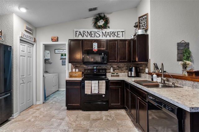 kitchen with washer and dryer, backsplash, vaulted ceiling, black appliances, and sink