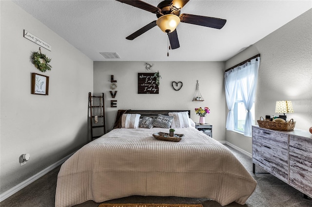 carpeted bedroom featuring ceiling fan and a textured ceiling