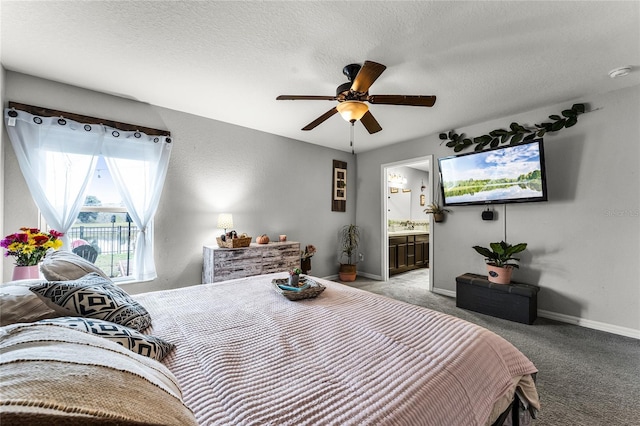 bedroom with ceiling fan, ensuite bath, light carpet, and a textured ceiling