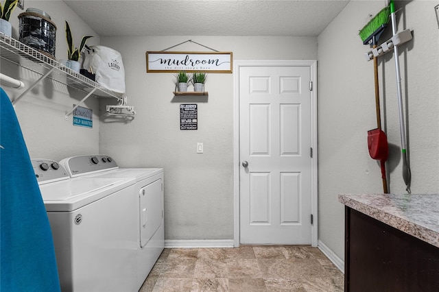 clothes washing area featuring a textured ceiling and washer and clothes dryer