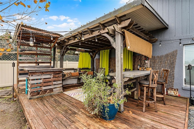 wooden terrace featuring a bar and an outdoor living space