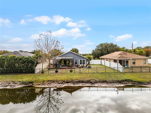 back of house featuring a water view and a yard