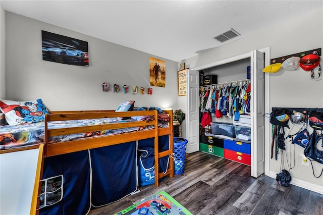 bedroom featuring a closet, dark hardwood / wood-style floors, and a textured ceiling