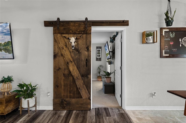 hall with a barn door and hardwood / wood-style flooring