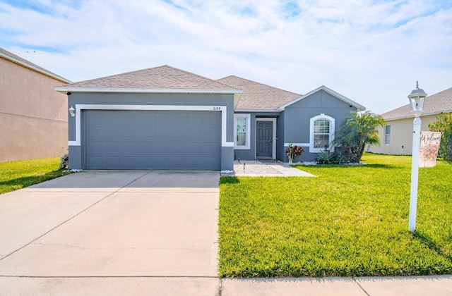 ranch-style home featuring a garage and a front lawn