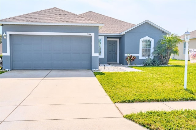 ranch-style house featuring a garage and a front yard