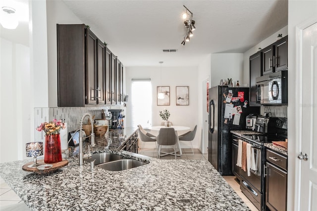 kitchen featuring light stone counters, sink, and black appliances