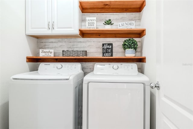 clothes washing area featuring cabinets and independent washer and dryer