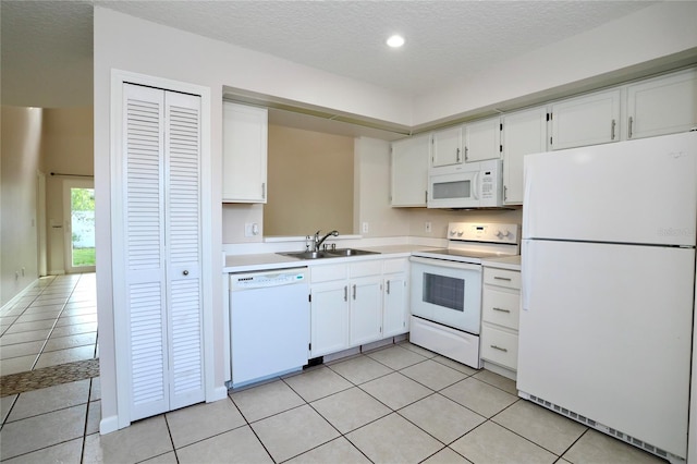 kitchen featuring white appliances, white cabinetry, a textured ceiling, and light tile patterned floors