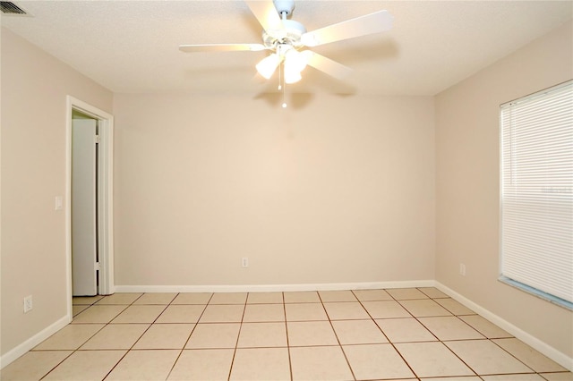 tiled spare room featuring ceiling fan