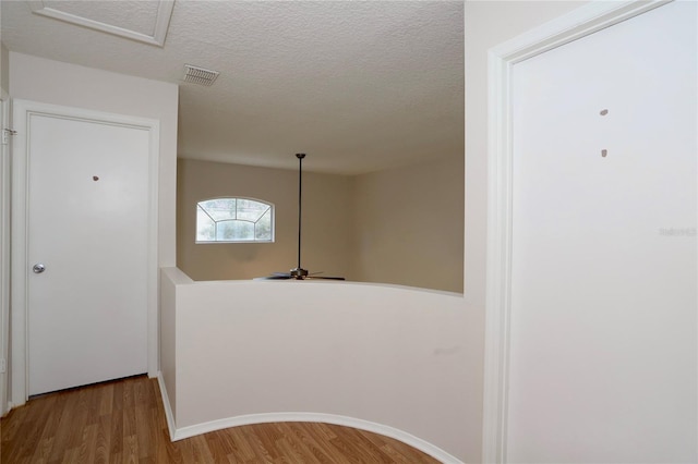 corridor featuring hardwood / wood-style floors and a textured ceiling