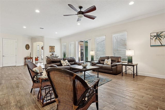 living room featuring ceiling fan, crown molding, and light wood-type flooring