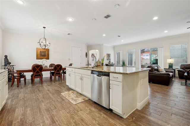 kitchen featuring a center island with sink, stainless steel dishwasher, hanging light fixtures, light wood-type flooring, and white cabinets