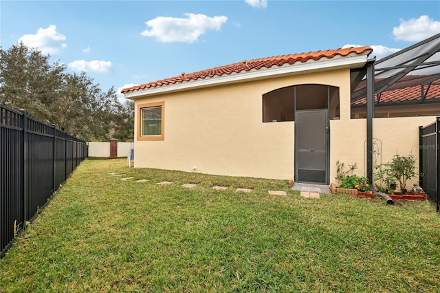 exterior space with a lanai and a lawn