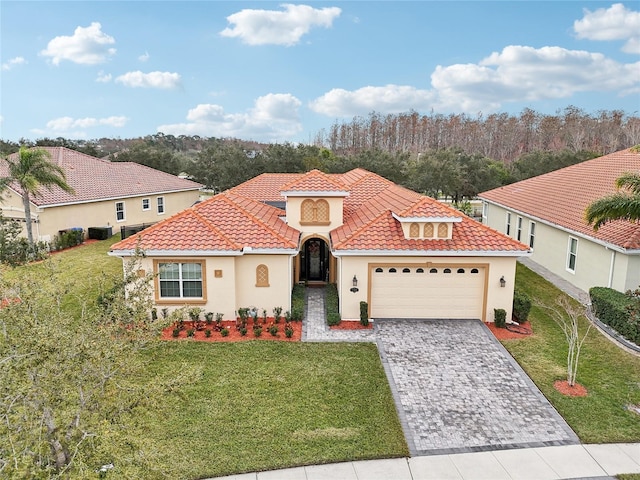 mediterranean / spanish-style house featuring a garage and a front yard