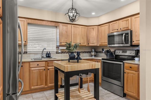 kitchen featuring decorative light fixtures, an inviting chandelier, backsplash, appliances with stainless steel finishes, and sink