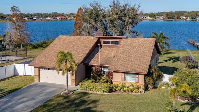 view of front of house featuring a garage, a water view, and a front lawn