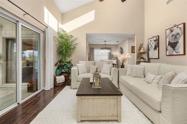 living room featuring ceiling fan with notable chandelier, vaulted ceiling, and hardwood / wood-style floors