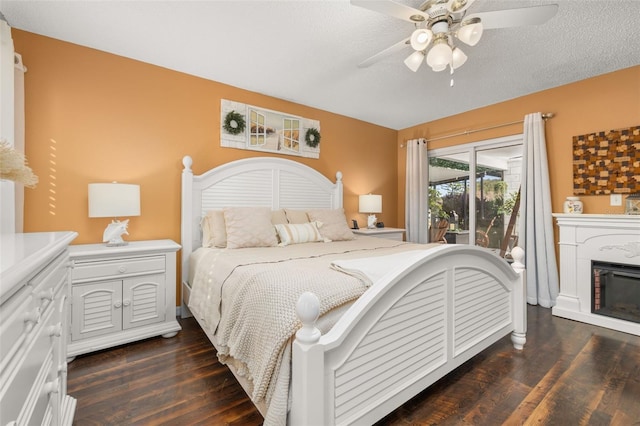 bedroom featuring ceiling fan, access to outside, a textured ceiling, and dark hardwood / wood-style floors