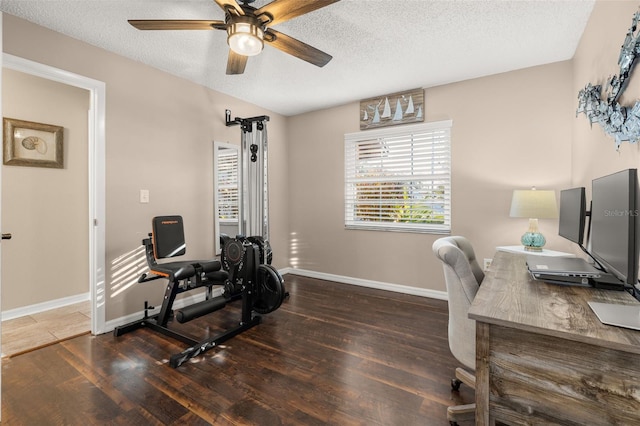 home office with a textured ceiling and dark hardwood / wood-style flooring