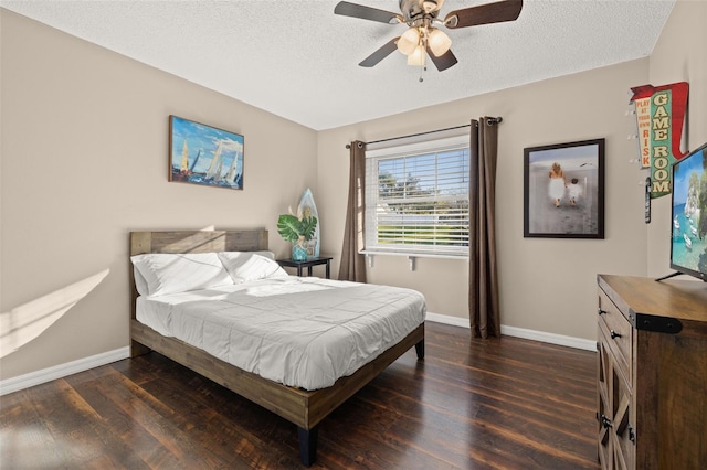 bedroom featuring dark wood-type flooring, a textured ceiling, and ceiling fan