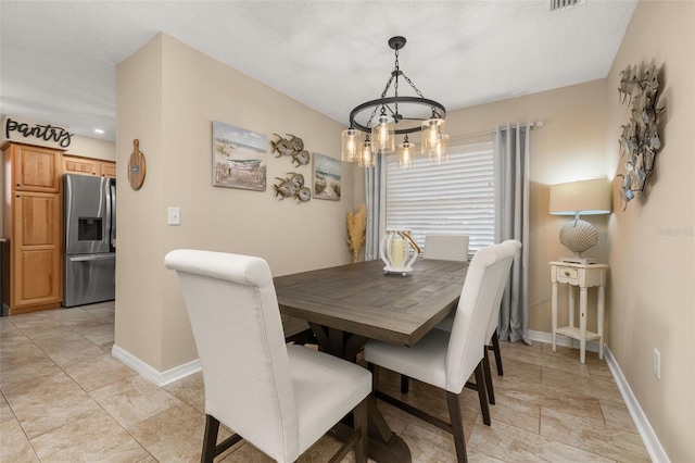 dining space featuring a textured ceiling and a chandelier