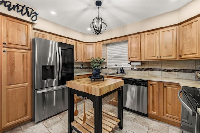 kitchen featuring sink, tasteful backsplash, hanging light fixtures, and appliances with stainless steel finishes