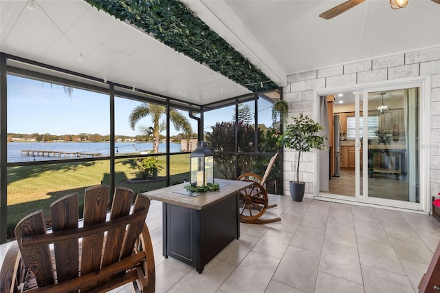 sunroom / solarium with ceiling fan and a water view