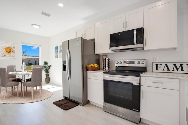 kitchen featuring light wood-type flooring, white cabinets, and appliances with stainless steel finishes