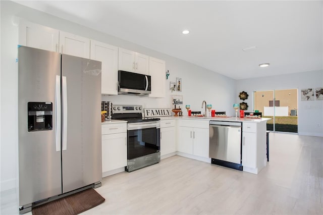 kitchen with sink, light hardwood / wood-style flooring, kitchen peninsula, stainless steel appliances, and white cabinets