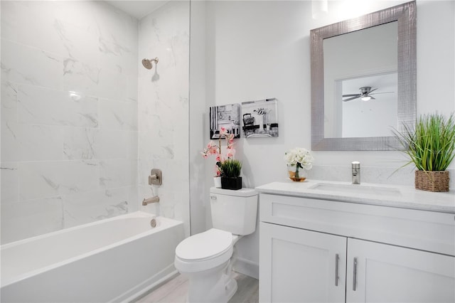 full bathroom featuring tiled shower / bath, vanity, and toilet