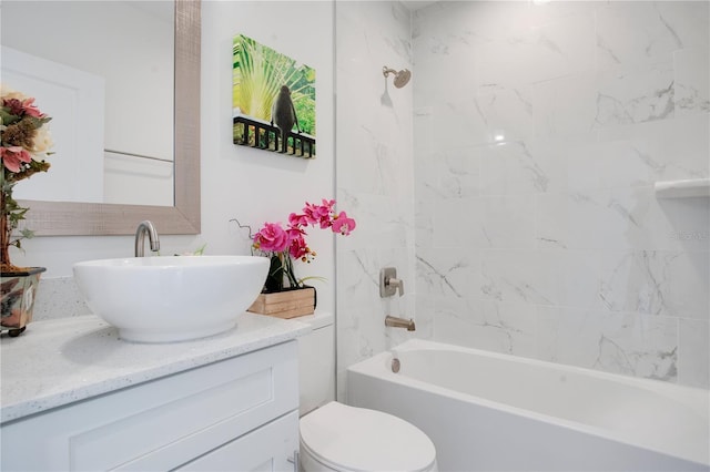 full bathroom featuring vanity, tiled shower / bath combo, and toilet