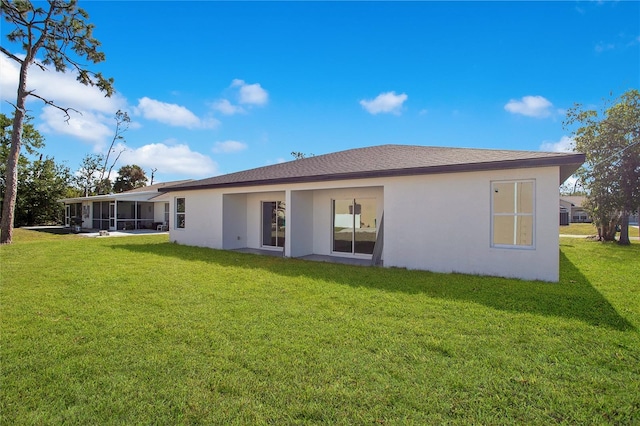 rear view of property featuring a lawn and a sunroom